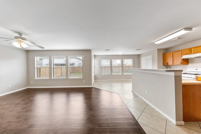 kitchen featuring ceiling fan, white gas range, and light tile patterned floors