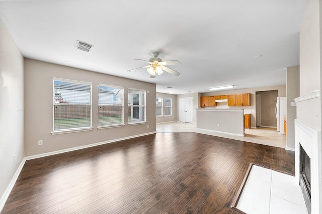 unfurnished living room with ceiling fan and light wood-type flooring