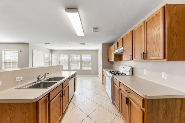 kitchen featuring sink, stainless steel dishwasher, light tile patterned floors, and white gas range oven