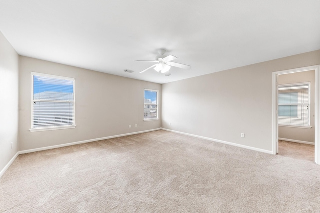 carpeted spare room with ceiling fan