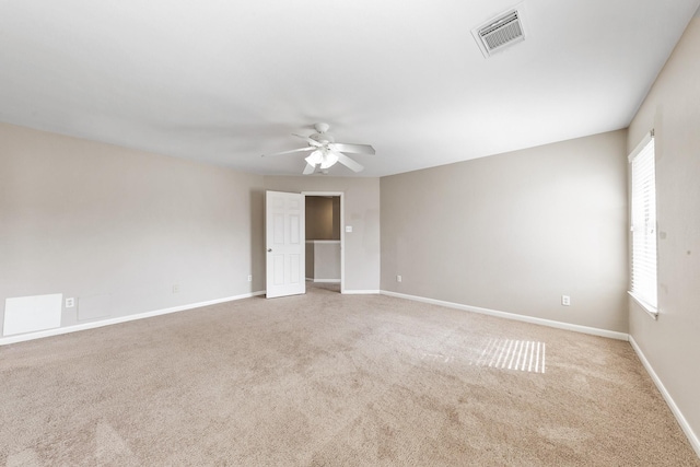 spare room featuring light colored carpet and ceiling fan