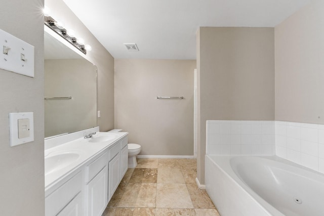 bathroom with vanity, a bathtub, and toilet