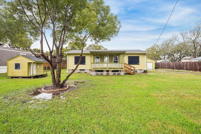 view of front facade with a shed, a deck, and a front lawn