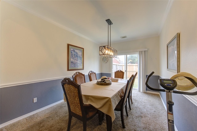 carpeted dining room with ornamental molding