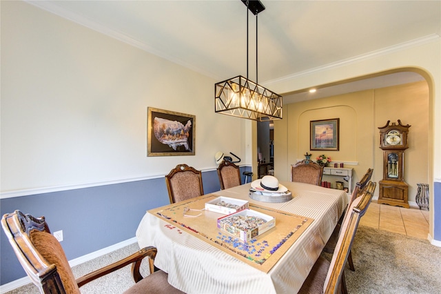 carpeted dining space featuring ornamental molding