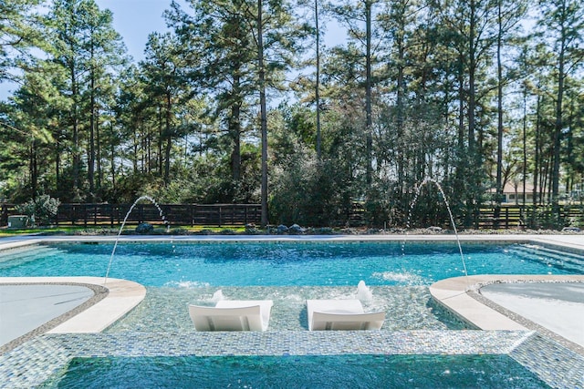 view of swimming pool featuring fence