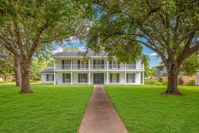 view of front of home featuring a front yard and a balcony