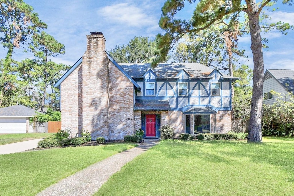 english style home featuring a front yard