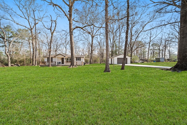 view of yard with a garage, an outdoor structure, and covered porch