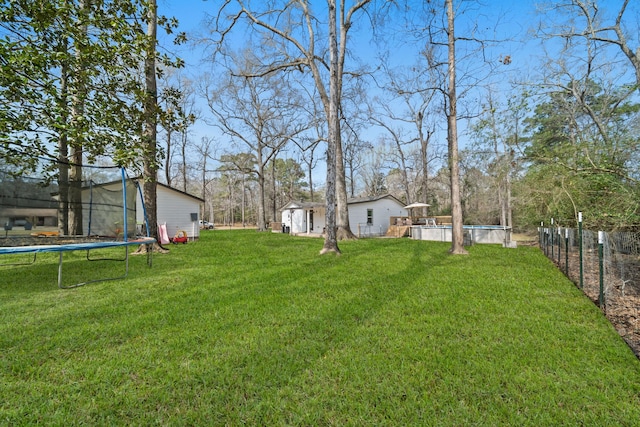 view of yard featuring a storage unit and a trampoline