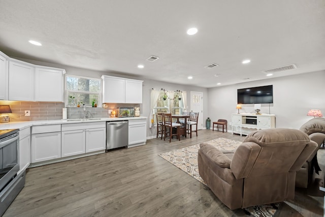 kitchen featuring sink, stainless steel appliances, dark hardwood / wood-style floors, white cabinets, and decorative backsplash