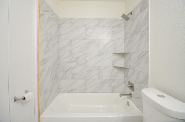 bathroom with tiled shower / bath combo and toilet