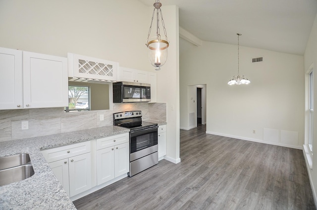 kitchen featuring appliances with stainless steel finishes, white cabinetry, hanging light fixtures, light stone counters, and light hardwood / wood-style floors