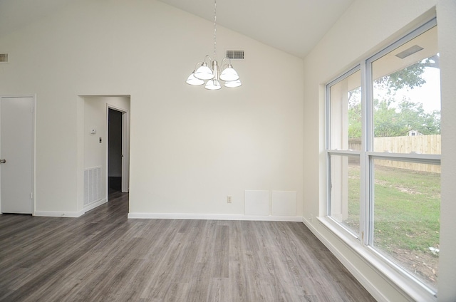 unfurnished dining area featuring hardwood / wood-style flooring, high vaulted ceiling, and a chandelier