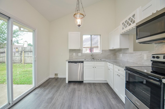 kitchen featuring hanging light fixtures, white cabinetry, appliances with stainless steel finishes, and sink