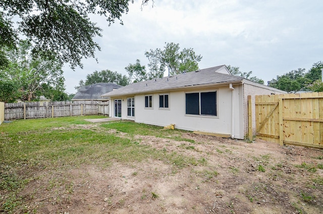 rear view of house featuring a yard