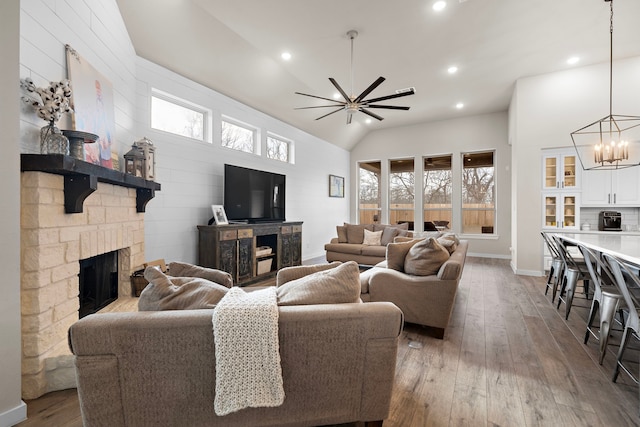 living room featuring light hardwood / wood-style flooring, a stone fireplace, and plenty of natural light