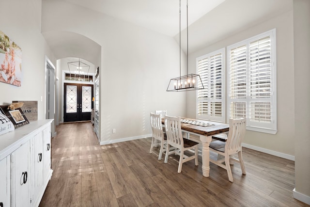 dining room featuring french doors, an inviting chandelier, and hardwood / wood-style flooring