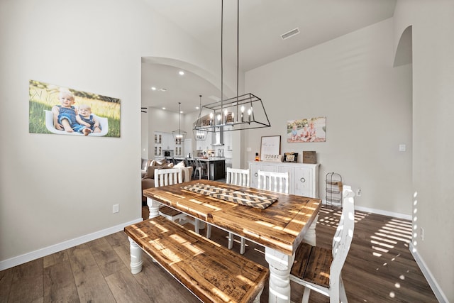 dining area with a notable chandelier and dark hardwood / wood-style flooring