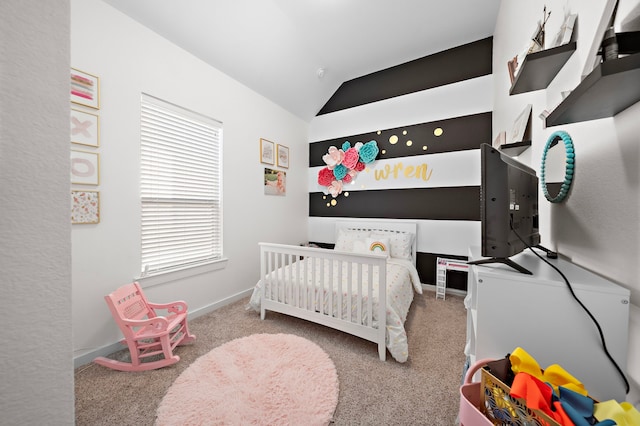 bedroom with a crib, lofted ceiling, and carpet