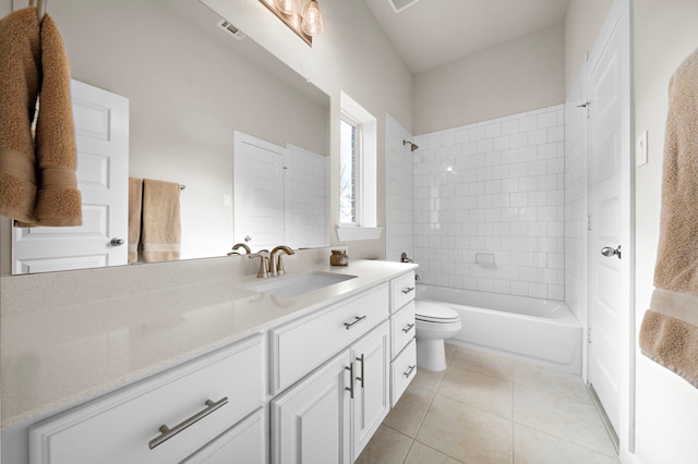 full bathroom featuring vanity, tiled shower / bath combo, tile patterned floors, and toilet