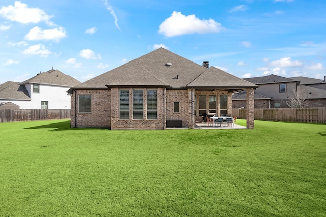 rear view of property featuring a patio area and a lawn