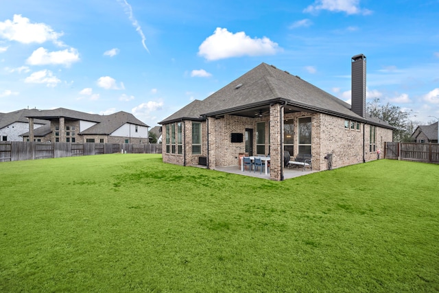 back of property with a lawn, ceiling fan, and a patio area