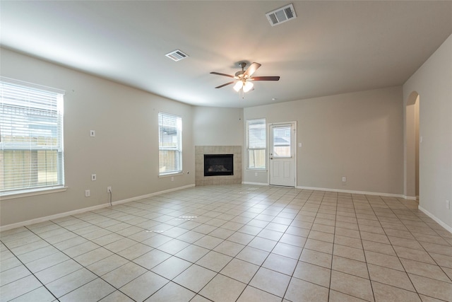 unfurnished living room with light tile patterned floors, a tile fireplace, and ceiling fan