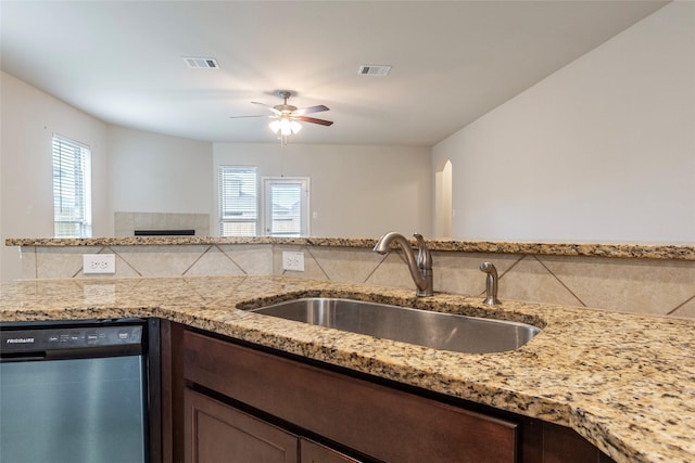 kitchen featuring sink, plenty of natural light, light stone countertops, and dishwasher