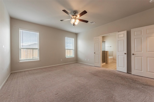 unfurnished bedroom with light carpet, ceiling fan, and ensuite bathroom