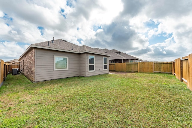 rear view of house with a yard and central AC unit