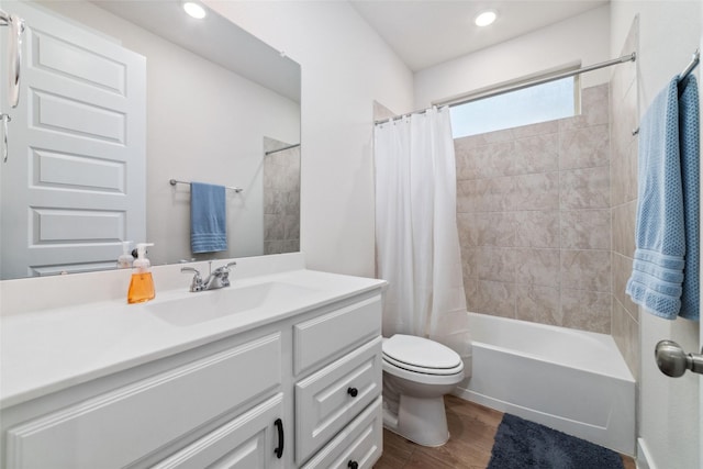 full bathroom with wood-type flooring, toilet, shower / bath combo with shower curtain, and vanity