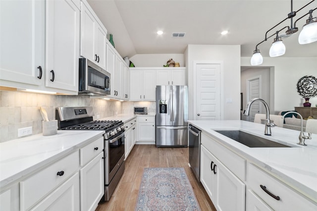 kitchen with sink, appliances with stainless steel finishes, and white cabinets