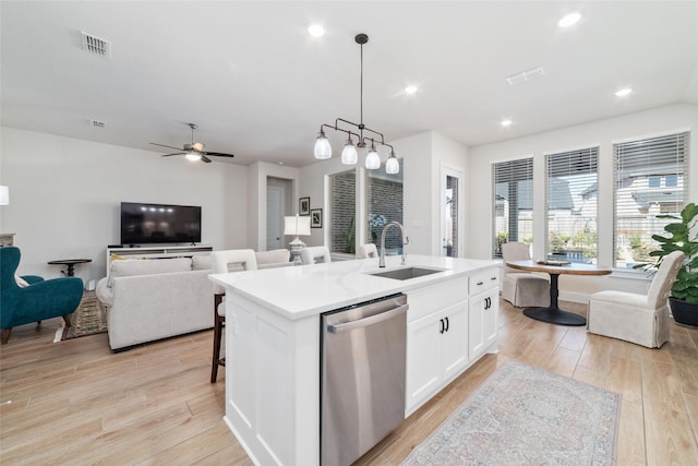 kitchen with sink, white cabinetry, dishwasher, decorative light fixtures, and a kitchen island with sink