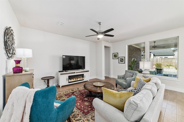 living room featuring light hardwood / wood-style flooring and ceiling fan