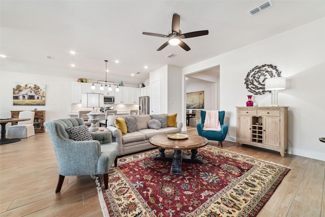 living room featuring light wood-type flooring and ceiling fan