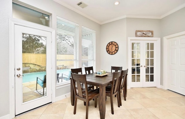 dining room with a wealth of natural light, visible vents, crown molding, and french doors