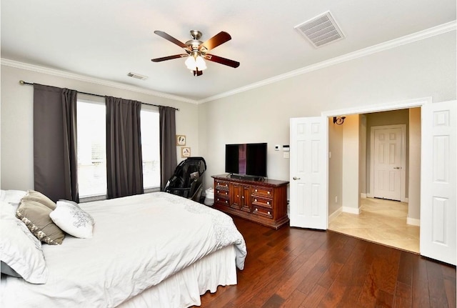 bedroom with dark wood-style floors, visible vents, and ornamental molding