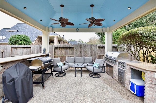 view of patio / terrace with grilling area, area for grilling, ceiling fan, a fenced backyard, and an outdoor living space