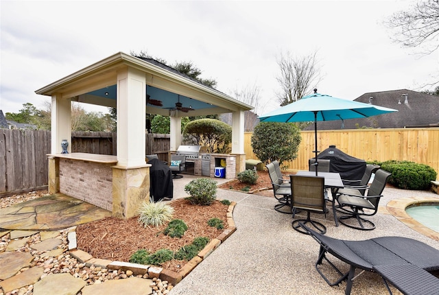 view of patio / terrace with a gazebo, exterior kitchen, grilling area, and a fenced backyard