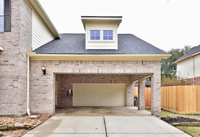 garage featuring driveway and fence