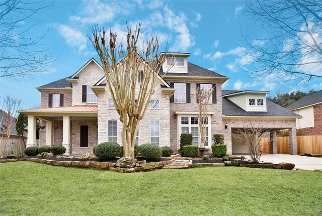 view of front of home featuring concrete driveway, roof with shingles, fence, a front lawn, and brick siding