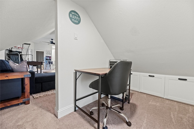 office area featuring baseboards, lofted ceiling, ceiling fan, a textured ceiling, and light colored carpet