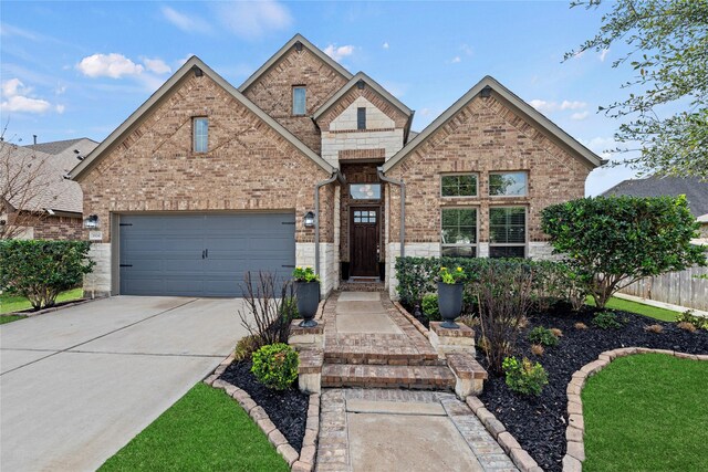 view of front facade featuring stone siding, a garage, brick siding, and driveway