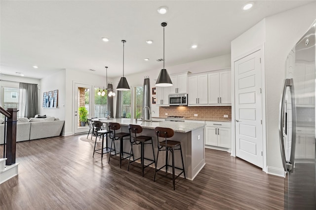 kitchen featuring white cabinetry, dark wood-style flooring, tasteful backsplash, and appliances with stainless steel finishes