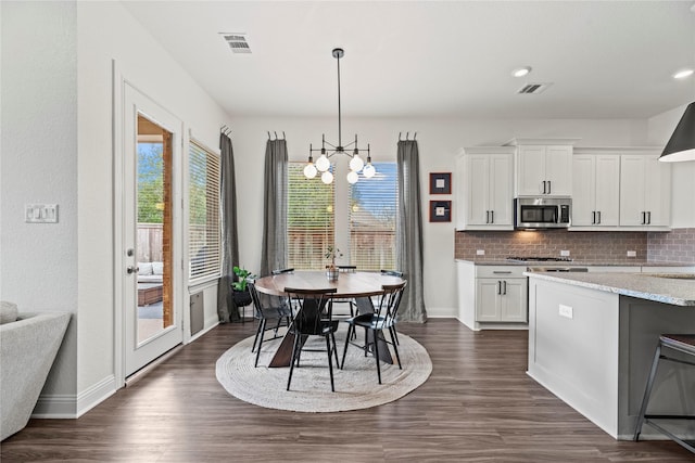 kitchen featuring visible vents, appliances with stainless steel finishes, white cabinetry, a notable chandelier, and backsplash