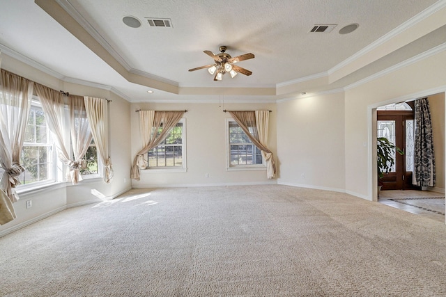 carpeted empty room with a raised ceiling, ornamental molding, ceiling fan, and a textured ceiling