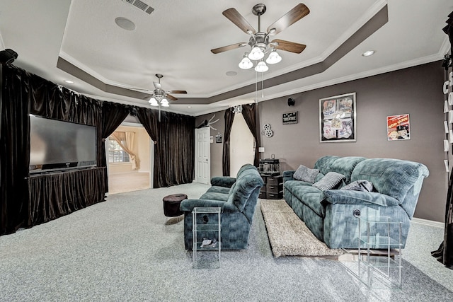 cinema with crown molding, ceiling fan, and a tray ceiling