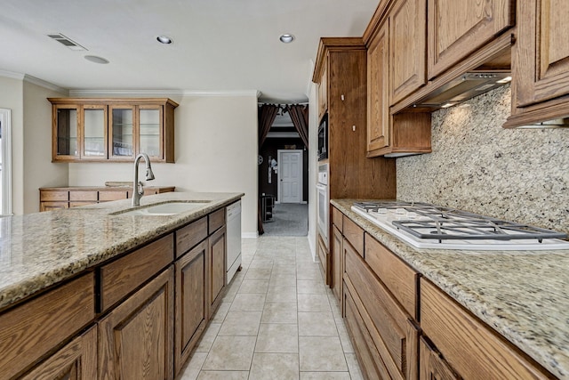 kitchen with crown molding, light stone countertops, sink, and white appliances