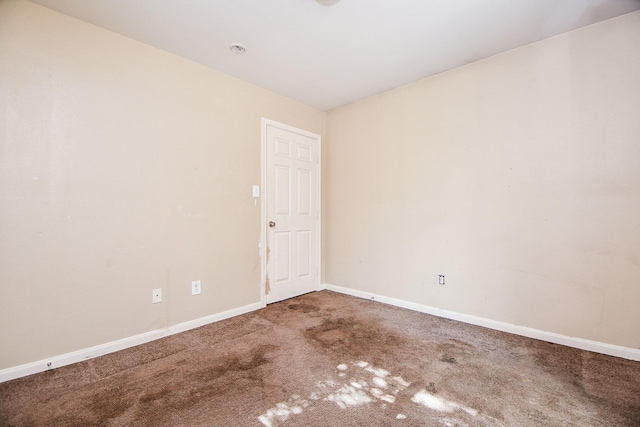 empty room featuring carpet floors and baseboards